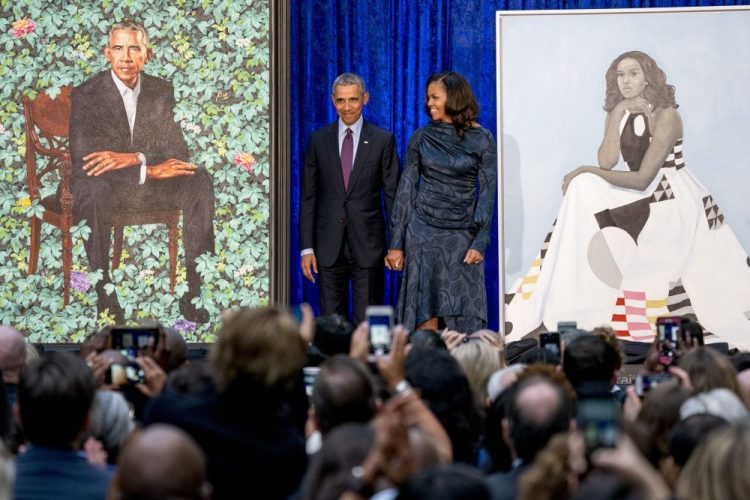FILE - In this Feb. 12, 2018, file photo, former President Barack Obama and former first lady Michelle Obama stand on stage together as their official portraits are unveiled at a ceremony at the Smithsonian's National Portrait Gallery in Washington. The portraits will begin a five-city national tour in Chicago in June 2021. 