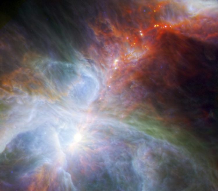 This image made available by NASA shows fledgling stars hidden in the gas and clouds of the Orion nebula, captured by infrared observations from the Spitzer Space Telescope and the European Space Agency's Herschel mission. In several hundred thousand years, some of the forming stars will accrete enough material to trigger nuclear fusion at their cores. (ESA/NASA/JPL-Caltech/N. Billot (IRAM) via AP)