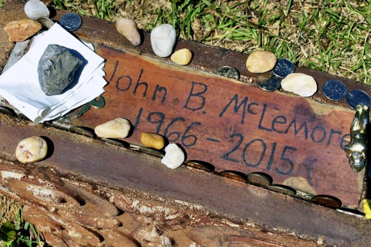 This May 3, 2017, file photo, shows the grave of John B. McLemore in Green Pond, Ala., who is featured in the serialized podcast "S-Town." WIAT-TV reported that lawyers for the estate of McLemore, the key character in "S-Town," and attorneys for the producer have selected a mediator to work on a settlement. 