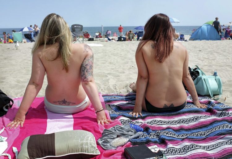 Women go topless during Go Topless Day at Hampton Beach, N.H., in 2017. The U.S. Supreme Court is leaving in place the public nudity convictions of three women who removed their bathing suit tops on a New Hampshire beach as part of a campaign advocating for the rights of women to go topless. 