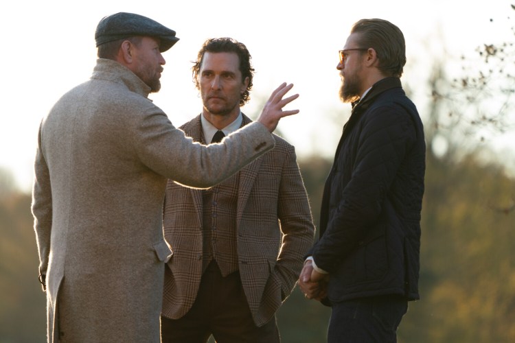 Director Guy Ritchie, left, talks about a scene of  in "The Gentlemen" with Matthew McConaughey, center, and Charlie Hunnam.
