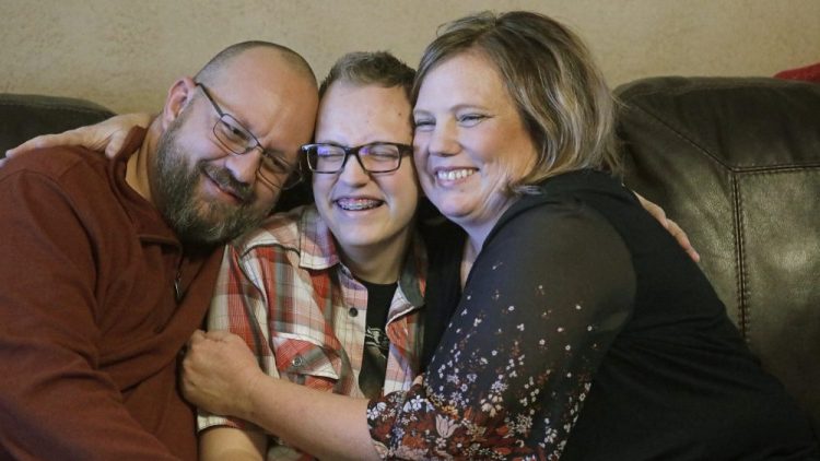 Dex Rumsey, 15, with his mother Robyn and father Clay in Roy, Utah. Dex came out as transgender at age 12. In consultation with a counselor and doctors, he began using puberty blockers and eventually testosterone. His parents say he's gone from a shy, withdrawn child to a happy, thriving kid. He says he's scared he could become depressed and suicidal again if a ban on hormone therapy and sex-reassignment surgery for minors were to pass. 