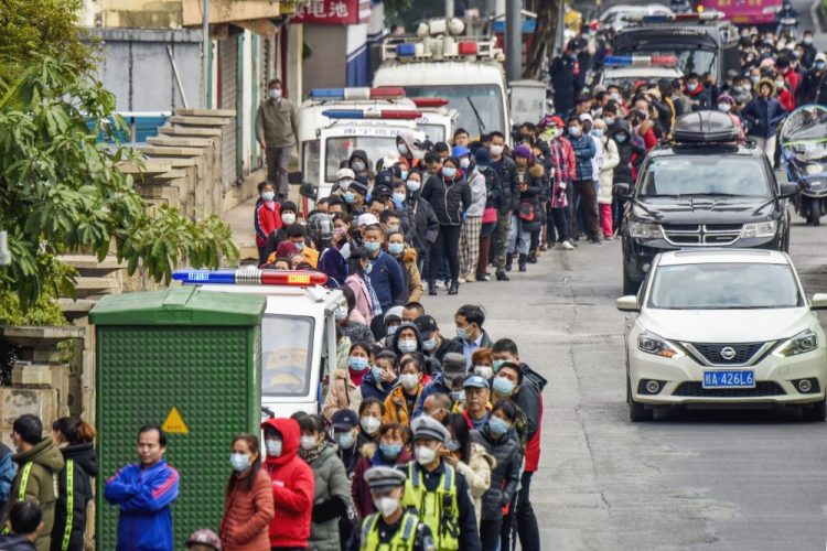 In this Jan. 29, 2020 photo, people line up to buy face masks from a medical supply company in Nanning in southern China's Guangxi Zhuang Autonomous Region. 