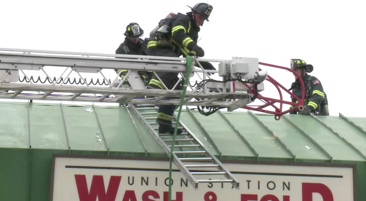Firefighters work at the site of a fire at the Union Station Wash & Fold laundromat on Tuesday. 