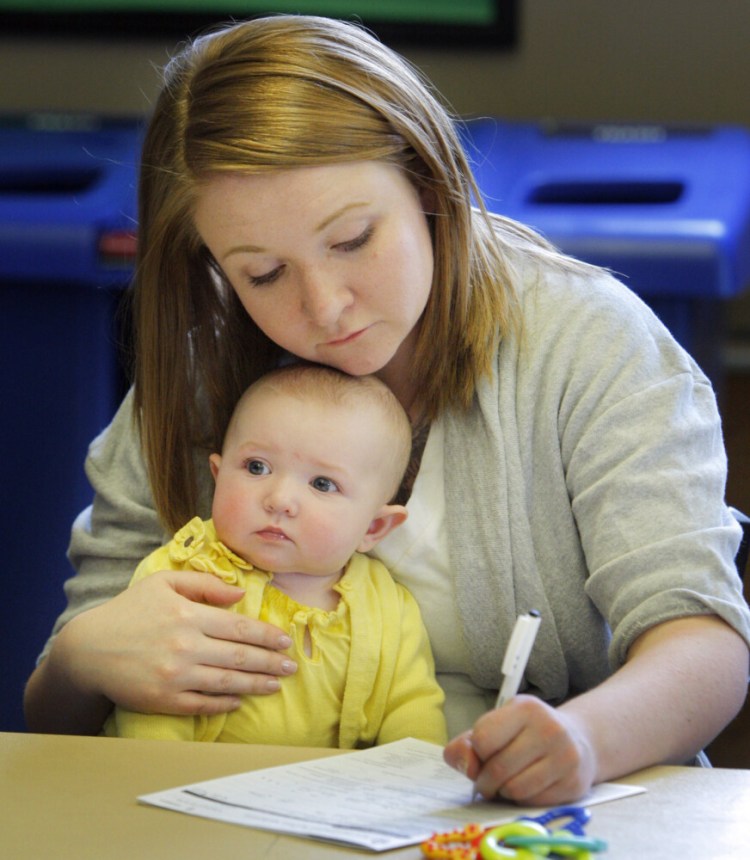 Shelly Fanjoy of Portland holds onto her daughter Josephine, 5 months, while filling out the paperwork for the $500 Alfond Grant in 2012. The $500 Alfond Grant is available to all Maine babies. 

