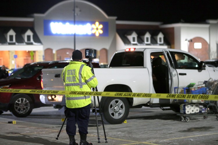 An investigator sets up survey equipment at the scene of Friday's shooting in the parking lot of the Walmart in Scarborough.