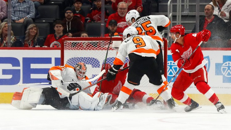 Philadelphia Flyers goaltender Brian Elliott  stops a Detroit Red Wings left wing Darren Helm during the Flyers' 3-0 win Monday in Detroit.