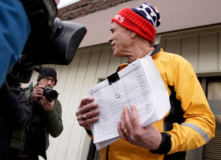 Precinct captain Carl Voss of Des Moines holds voter registration forms that he tried to deliver to the Iowa Democratic Party headquarters in Des Moines on Tuesday. He found the headquarters unstaffed.