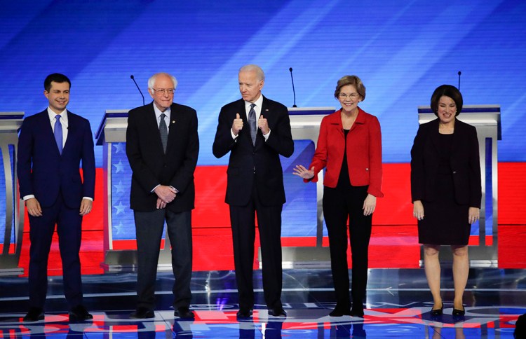 From left, Democratic presidential candidates Pete Buttigieg, Bernie Sanders, Joe Biden, Elizabeth Warren and Amy Klobuchar stand on stage before Friday's presidential debate at Saint Anselm College in New Hampshire.