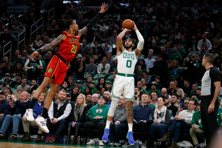 Boston's Jayson Tatum shoots one of his 7 3-pointers against Atlanta  forward John Collins during Friday's game in Boston. 

