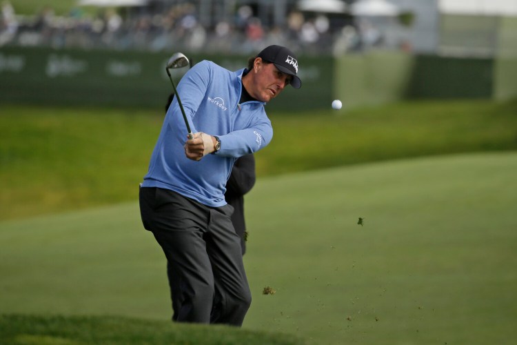 Phil Mickelson chips the ball up to the sixth green Saturday in Pebble Beach, Calif. 