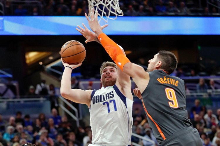 Luka Doncic, left, of Dallas, shoots over Orlando's Nikola Vucevic during Friday's game in Orlando, Fla. 