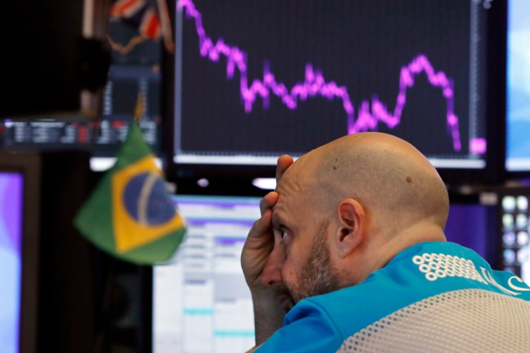 Specialist Meric Greenbaum works at his post on the floor of the New York Stock Exchange on Tuesday, Stocks slumped and bond prices soared for the second day in a row as fears spread that the widening virus outbreak will put the brakes on the global economy. 