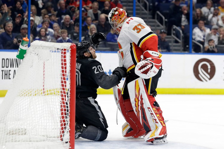 Calgary Flames goaltender David Rittich knocks down Tampa Bay Lightning center Blake Coleman after the two collided Saturday in Tampa, Fla.