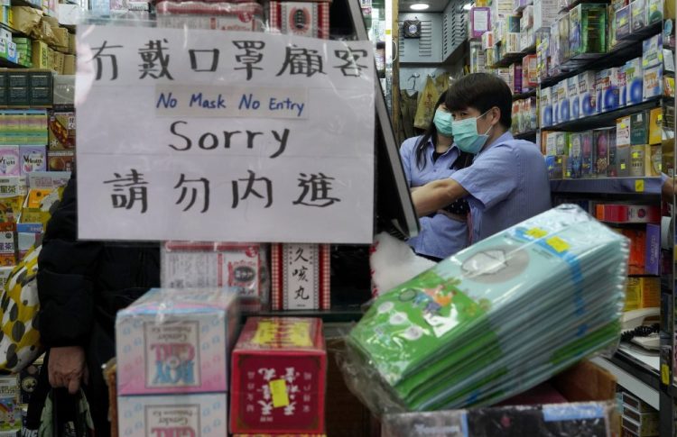 A notice announces no entry to customers without protective face masks at a pharmacy in Hong Kong on Monday. China is reporting a rise in new virus cases, denting optimism that disease control measures which isolated major cities might be working. 