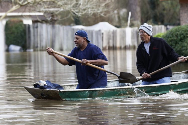 Jackson, Miss., homeowners use shovels to work their way through Pearl River floodwater on Sunday. Residents of Jackson braced Sunday for the possibility of catastrophic flooding in and around the capital as the river rose precipitously after days of torrential rain. 