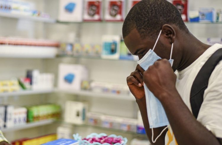 A man tries on a face mask Thursday at a pharmacy in Kitwe, Zambia.