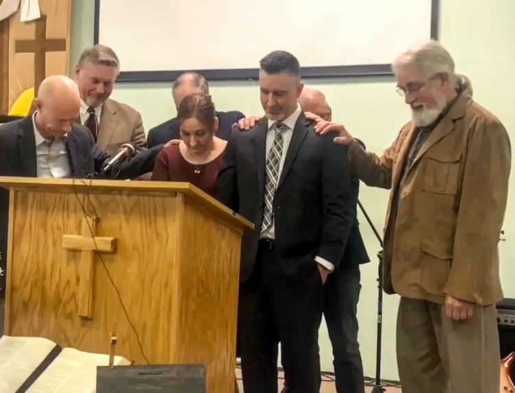 Pastors from Faith Church in Waterville lay hands on Mary and Pastor Benjamin Franklin during a pastoral  installation service Sunday at New Hope Evangelical Free Church in Solon.