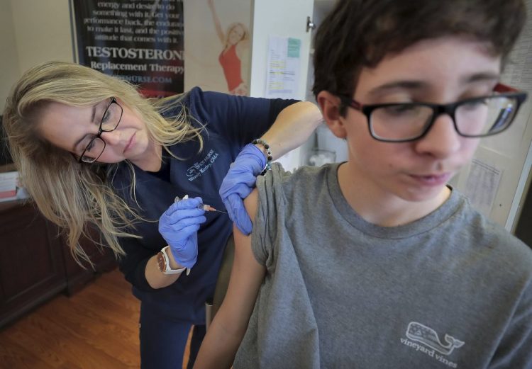 Wendy Kerley gives Ethan Getman, 15, a shot of the flu vaccine on Jan. 3 at the Cordova Shot Nurse clinic in Memphis, Tenn. A second wave of flu is hitting the U.S., turning this into one of the nastiest flu seasons for children in a decade.