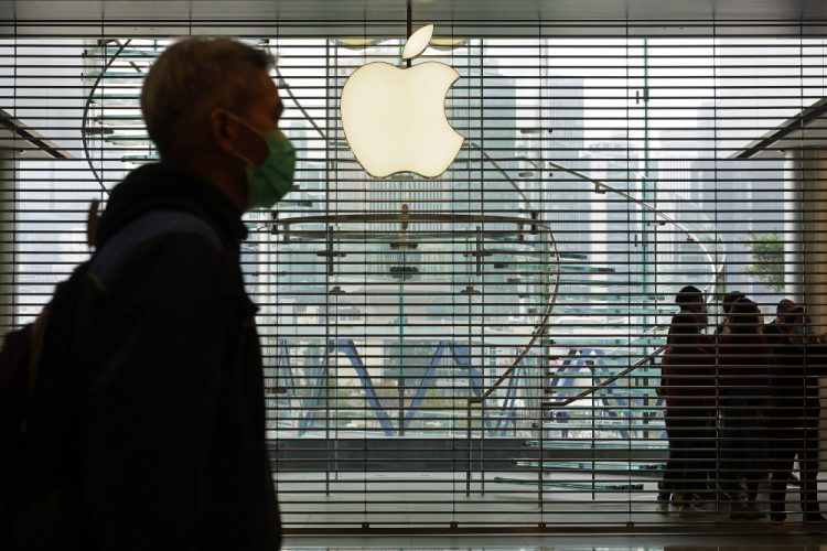 A man wearing a face mask walks past an Apple store in Hong Kong on Sunday. Apple is temporarily closing its 42 stores in mainland China, one of its largest markets, as a new virus spreads rapidly. 