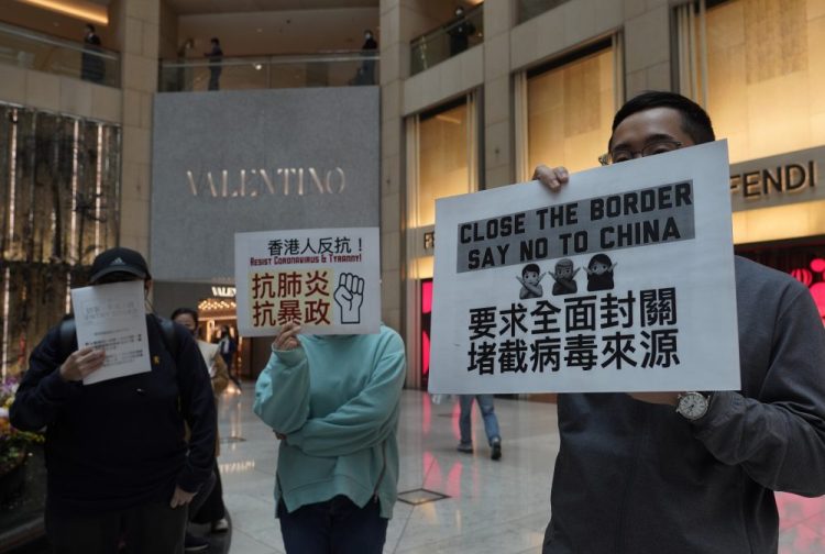 Protesters hold placards reads "Close the border, say no to China" during a protest at a mall in Hong Kong on Tuesday. 