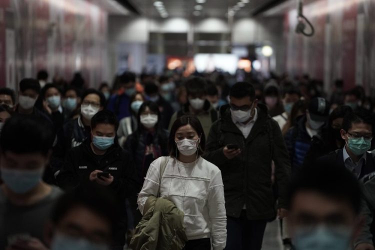 People wearing masks walk in a subway station Friday in Hong Kong.