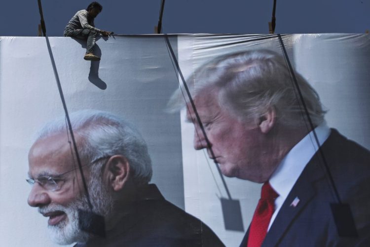 A worker installs a billboard image welcoming President Trump ahead of his visit, in Ahmadabad, India. Trump is scheduled to visit the city on Monday and Tuesday.