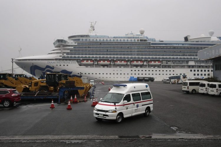 An ambulance leaves a port where the quarantined Diamond Princess cruise ship is docked Sunday in Yokohama, near Tokyo. The U.S. says Americans aboard the quarantined ship will be flown back home on a chartered flight Sunday, but that they will face another two-week quarantine.