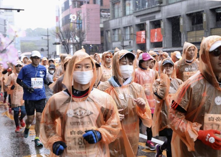 Runners - some wearing masks - compete in a marathon in Kumamoto in western Japan on Feb. 16. Organizers of the Tokyo Marathon set for March 1, are drastically reducing the number of participants out of fear of the spread of the coronavirus. The general public is essentially being barred from the race. 