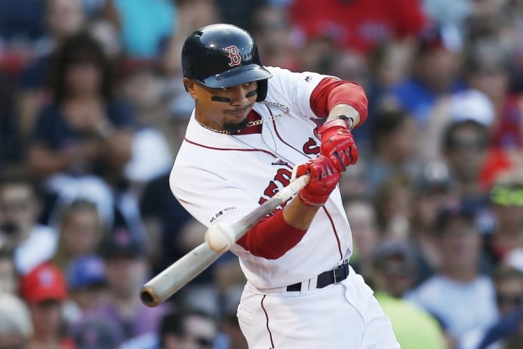 In this Aug. 10, 2019, file photo, Boston Red Sox's Mookie Betts hits an RBI-double during the sixth inning of a baseball game against the Los Angeles Angels in Boston. Betts was traded to the Los Angeles Dodgers this week.