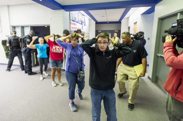 Students are led out of school as members of the Fountain Police Department take part in an Active Shooter Response Training exercise at Fountain Middle School in Fountain, Colo., in 2017. The nation's two largest teachers unions want schools to revise or eliminate active shooter drills, asserting they can harm students' mental health. 