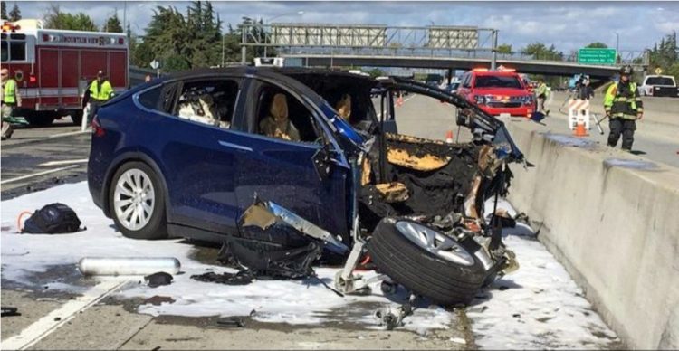 Emergency personnel work a the scene where a Tesla crashed into a barrier on U.S. Highway 101 in Mountain View, Calif., on March 23, 2018. The National Transportation Safety Board says Walter Huang, an Apple engineer who was driving the vehicle, was playing a video game on his smartphone at the time. The agency says the car’s forward collision avoidance system didn’t alert Huang.