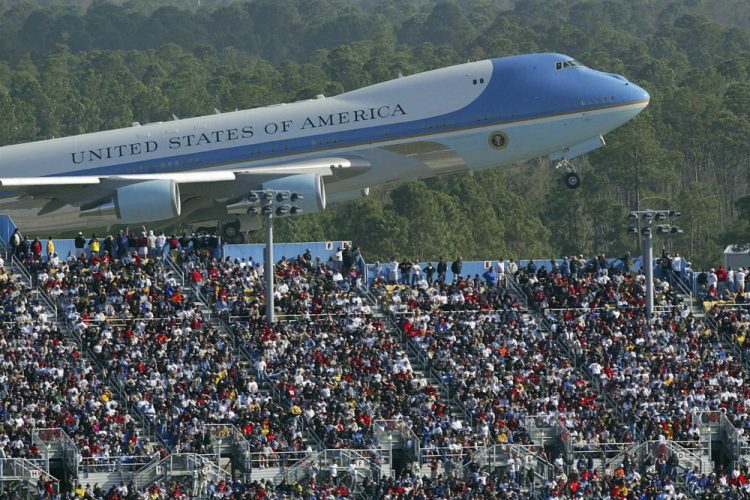 Air Force One rises above the packed grandstands along the super stretch at Daytona International Speedway in Daytona Beach, Fla., on Feb. 15, 2004. George W. Bush arrived before the race, talked with drivers along pit road and gave the command for drivers to start their engines.  