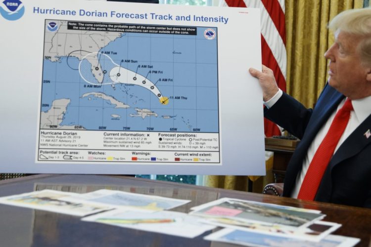 President Trump displays a chart after receiving a briefing on Hurricane Dorian in the Oval Office of the White House last year. Newly released emails from scientists and top officials at the federal agency responsible for weather forecasting illustrates the consternation and alarm caused by the president's false claim that Hurricane Dorian could hit Alabama. 