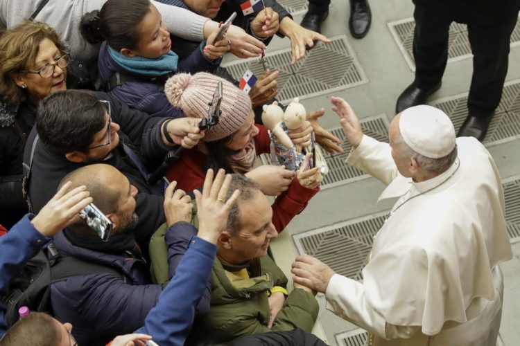 Pope Francis greets people during his weekly general audience Wednesday in the Pope Paul VI hall at the Vatican,.