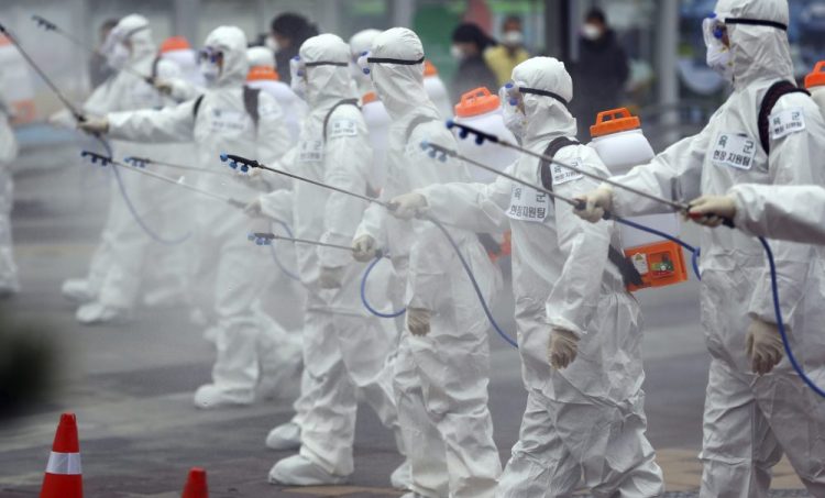 Army soldiers wearing protective suits spray disinfectant Saturday to prevent the spread of the new coronavirus at the Dongdaegu train station in Daegu, South Korea.