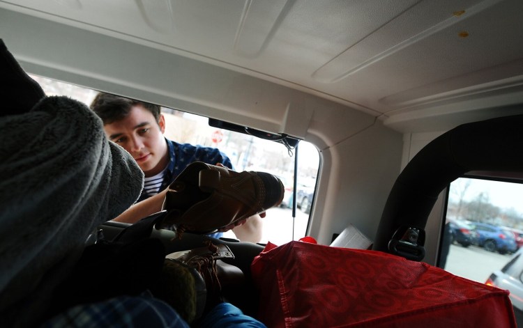 Colby College student Gabriel Dumoulin of Connecticut loads his belongs into his vehicle Sunday outside the Bill & Joan Alfond Main Street Commons, a Colby dorm in downtown Waterville.