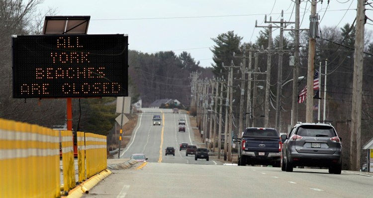 A sign on Route 1 in York alerts people Monday that beaches in the town are closed. York has shut down its public beaches because large numbers of people crowded beaches this past weekend, and other coastal towns in southern Maine are considering doing the same. 