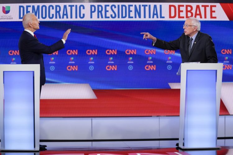 Former Vice President Joe Biden, left, and Sen. Bernie Sanders, I-Vt., right, participate in a Democratic presidential primary debate Sunday at CNN Studios in Washington.