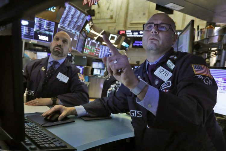 Specialists James Denaro, left, and Mario Picone work on the floor of the New York Stock Exchange on Tuesday. It was shaping up to be another volatile day on Wall Street.