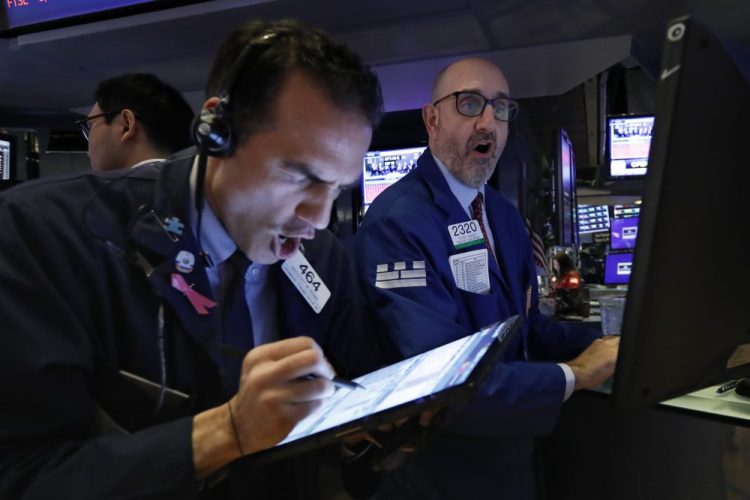 Trader Gregory Rowe, left, and specialist Peter Giacchi work on the floor of the New York Stock Exchange on Thursday morning.