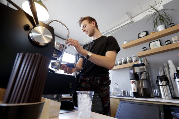 Barista Porter Hahn makes a drink for a customer in a coffee shop Nov. 4 in Seattle. U.S. services companies grew at a faster pace in February 2020 than the previous month, an indication that the economy is still expanding, despite growing concerns about global coronavirus outbreak.