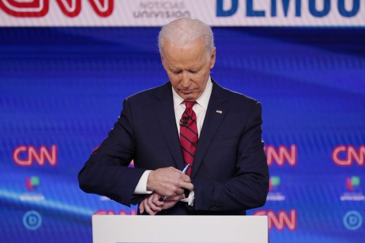 Former Vice President Joe Biden check his watch during a commercial break as he participates in a Democratic presidential primary debate Sunday at CNN Studios in Washington.