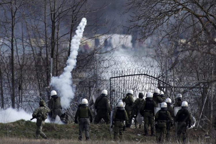 Greek police fire tear gas as migrants gather at a border fence on the Turkish side, during clashes in Kastanies, Greece, on Saturday. Thousands of refugees and other migrants have been trying to get into EU member Greece in the past week after Turkey declared that its previously guarded borders with Europe were open. 