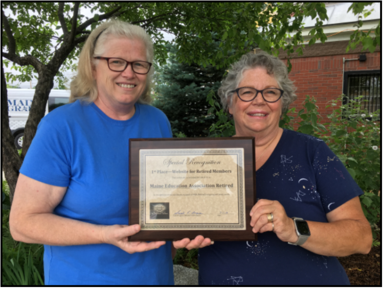 Communications Committee Chairperson Jane Conroy of Dover-Foxcroft, left, congratulates Web Administrator Pam Partridge of North Anson for her work in earning national recognition, First Place With Distinction.  