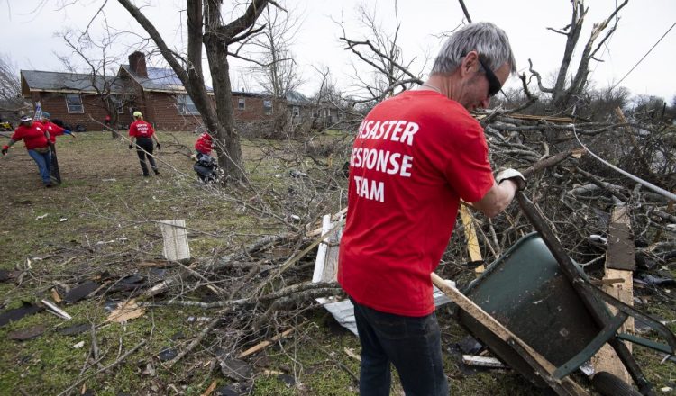 Russ Freeman works to clean up tornado debris along McGavock Pike on Wednesday in Nashville, Tenn. 