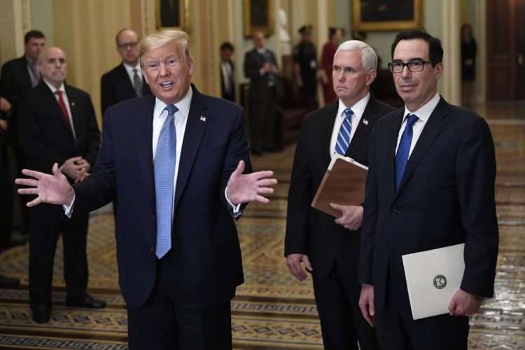 President Trump, along with standing with Vice President Mike Pence and Treasury Secretary Steven Mnuchin, right, talks to reporters about the coronavirus outbreak on Tuesday on Capitol Hill in Washington. 