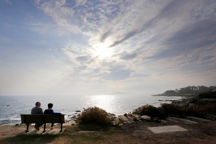  A couple looks out over the Atlantic Ocean from a bench at Two Lights State Park as the sun pokes through the clouds last year. Two Lights is among the parks and beaches that will remain closed at least until June 1. 
