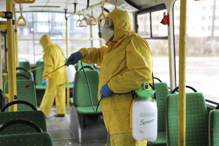 Employees wearing protective gear spray disinfect a bus as a preventive measure against the coronavirus in Lviv, Ukraine, on Tuesday. Ukrainian Chief sanitary and epidemiological doctor Viktor Liashko has just reported its first confirmed case of the virus. 
