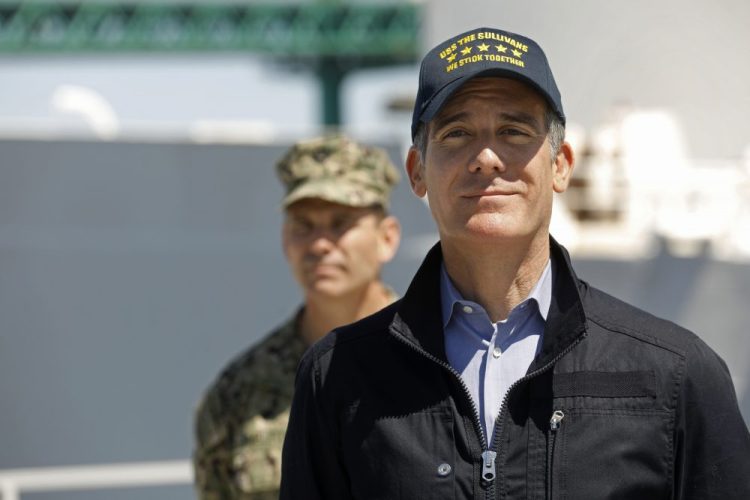 Los Angeles Mayor Eric Garcetti listens as California Gov. Gavin Newsom speaks in front of the Navy hospital ship Mercy that arrived at the Port of Los Angeles on Friday to provide relief for Southland hospitals overwhelmed by the coronavirus pandemic. Adm. John Gumbleton is behind Garcetti. 